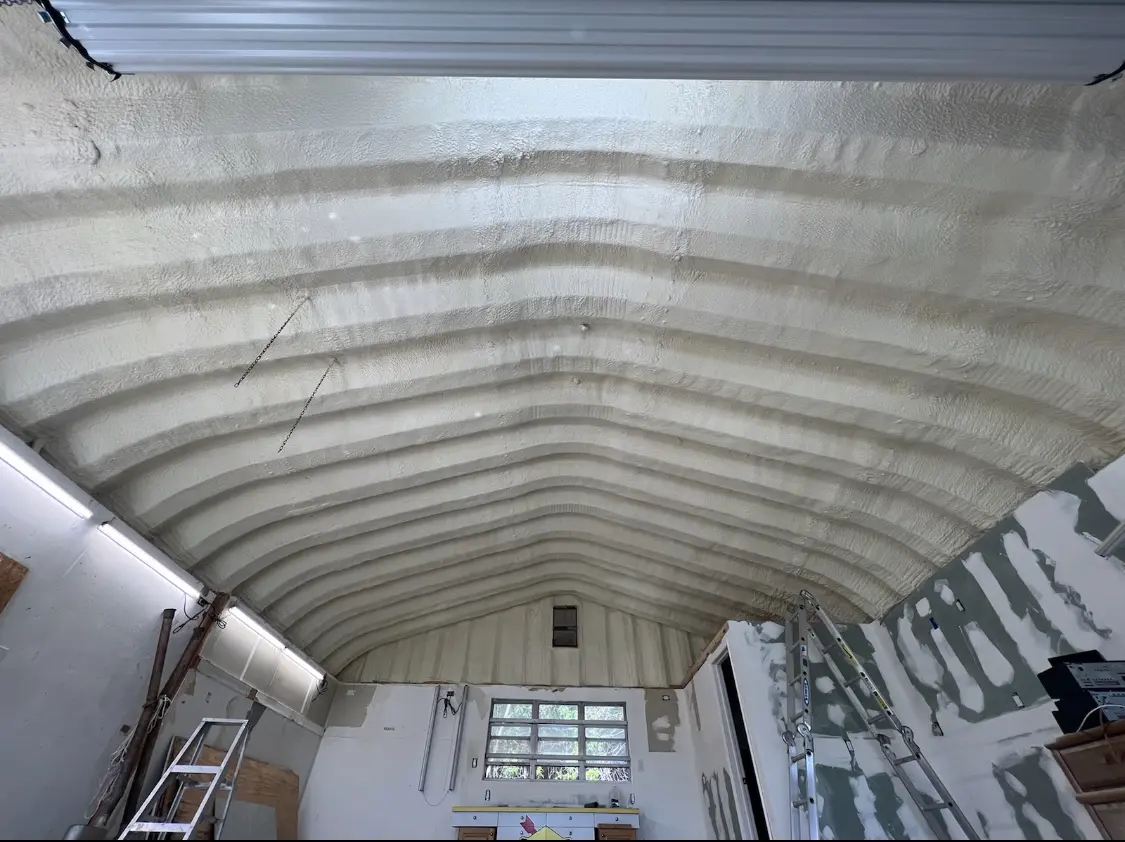 Spray polyurethane foam applied to the underside of a metal roof deck in Longview